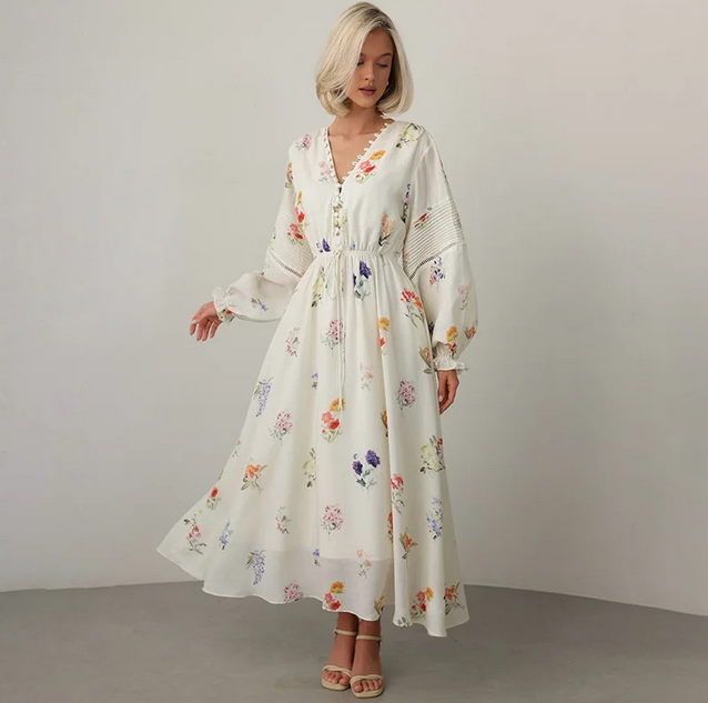 Willa wearing a flowy floral embroidered dress in ivory white
